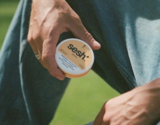 Man holding a SESH+™ mango nicotine pouch can.